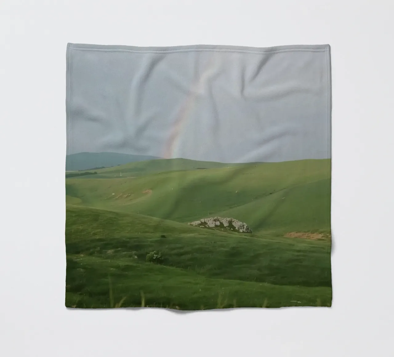 Colline verdi con arcobaleno e rocce coperta in pile da DesignDoodle