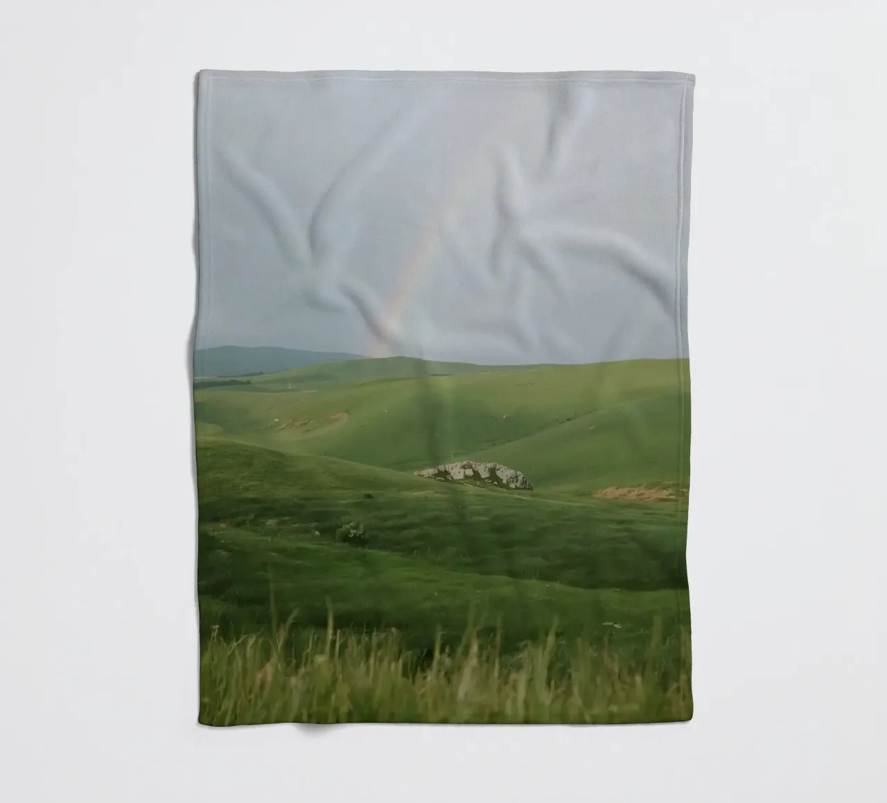 Colline verdi con arcobaleno e rocce coperta in pile da DesignDoodle