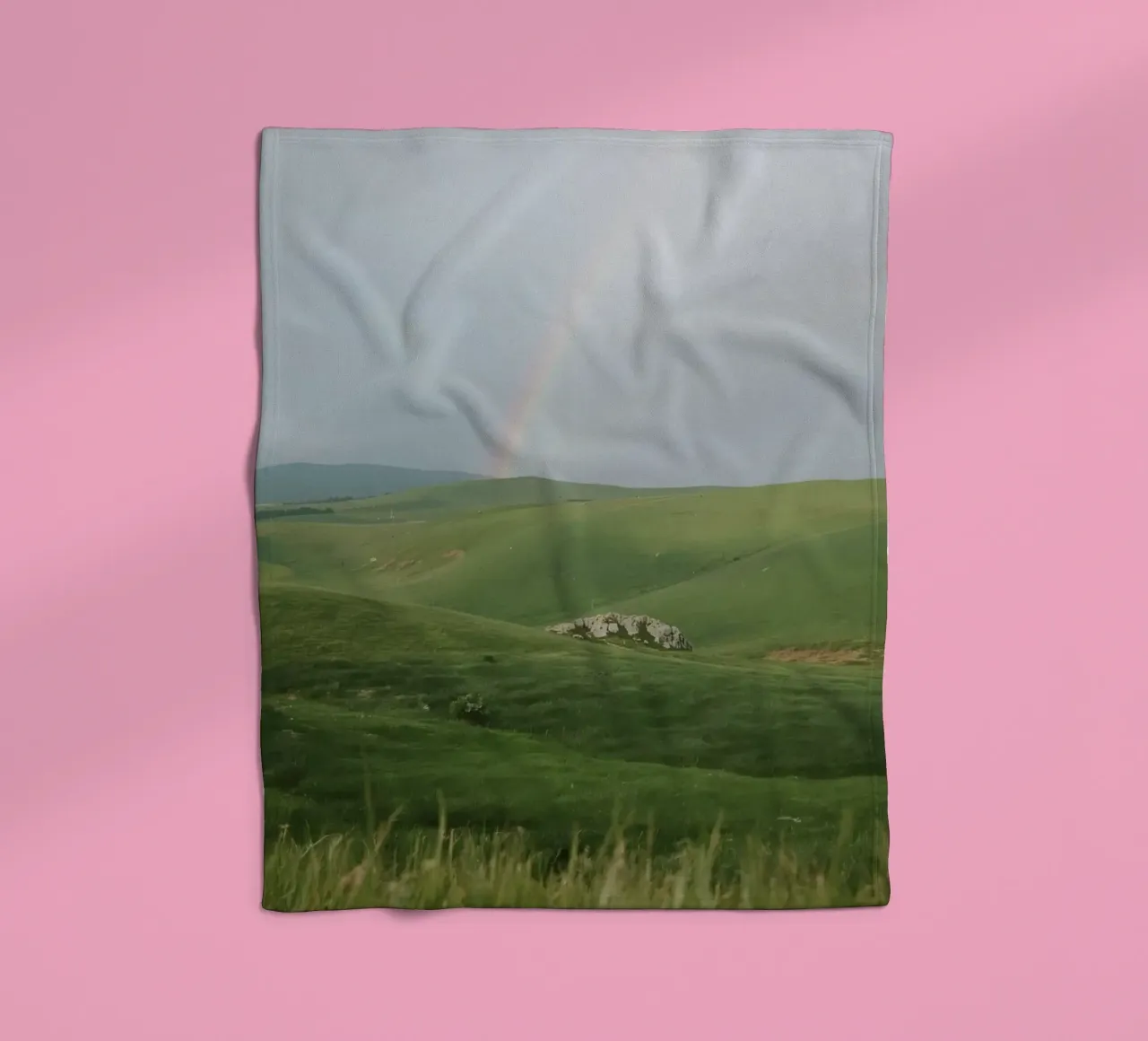 Colline verdi con arcobaleno e rocce coperta in pile da DesignDoodle