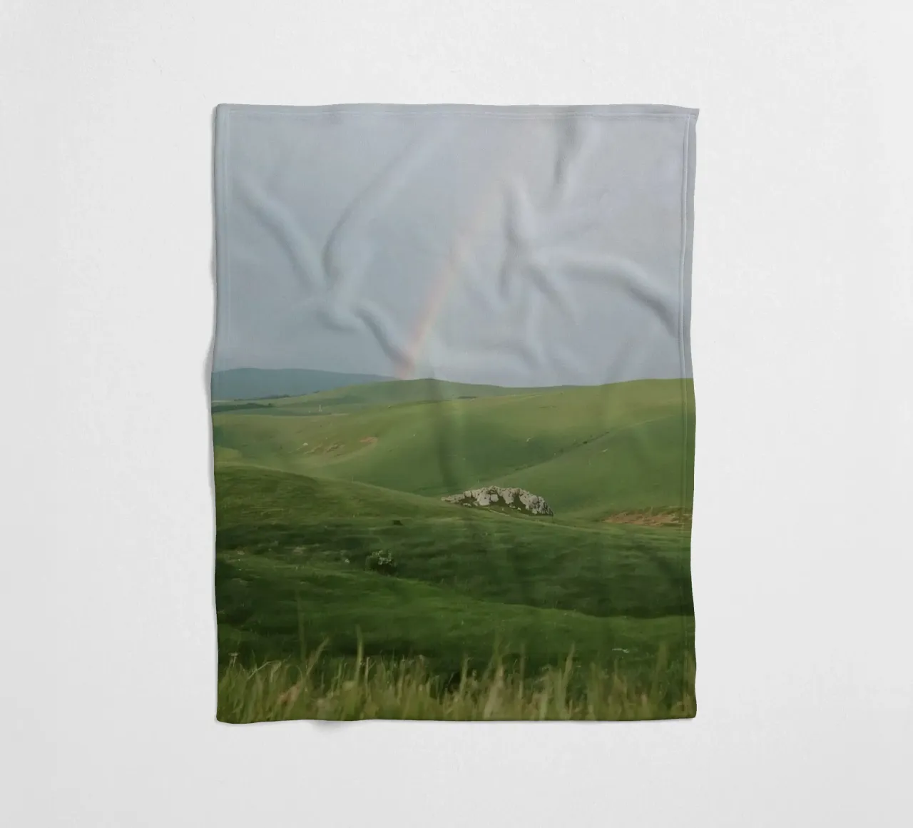 Colline verdi con arcobaleno e rocce coperta in pile da DesignDoodle