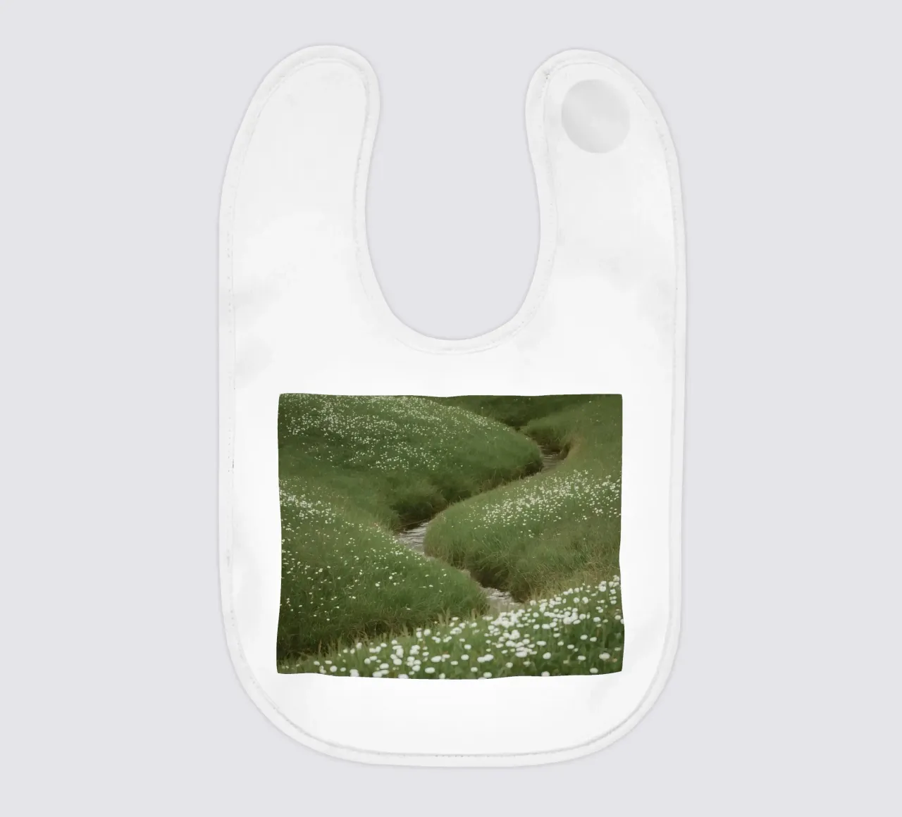 Verdi colline ondulate con ruscello e fiori selvatici bavaglino da DesignDoodle