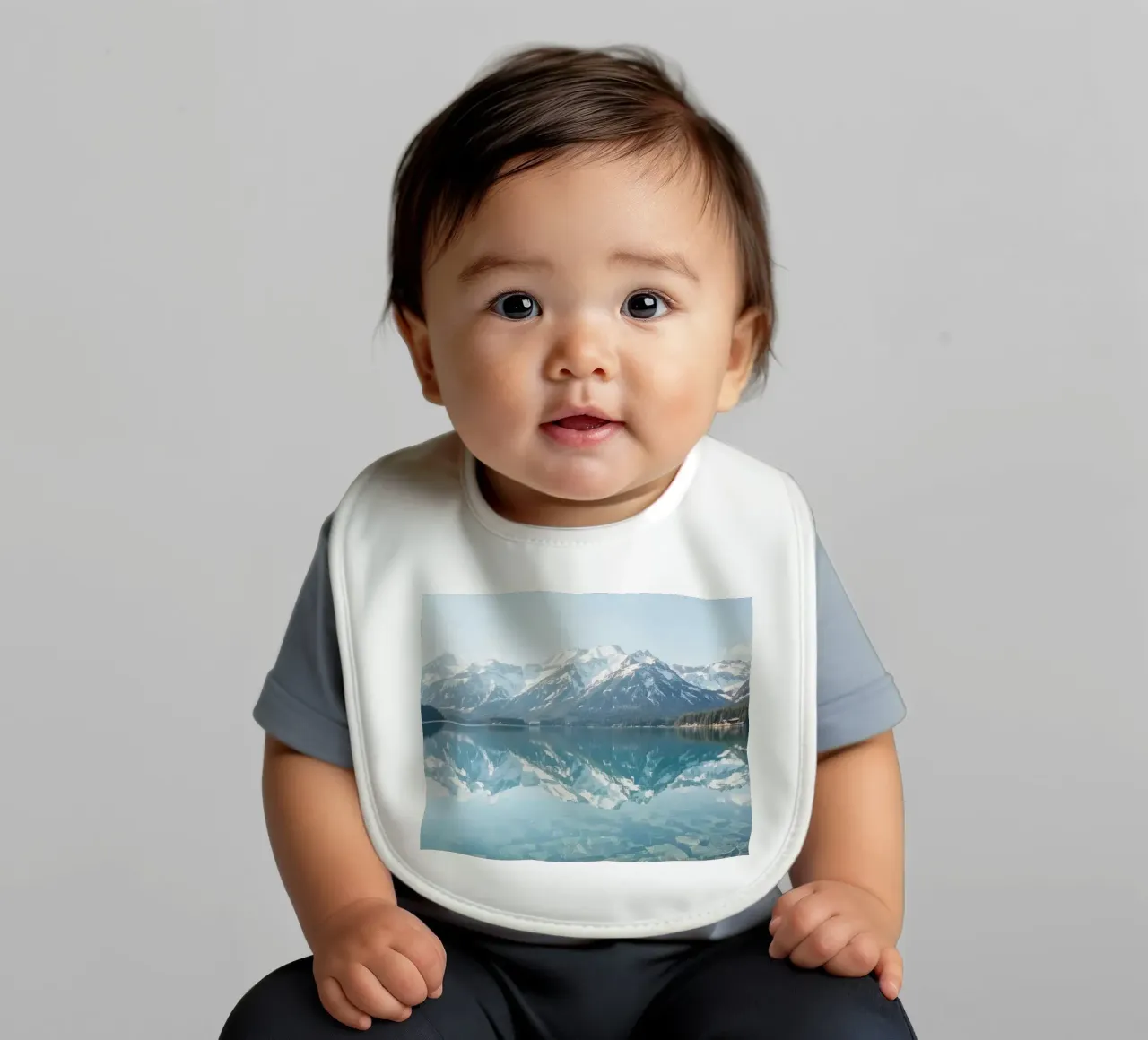 Montagne innevate che si riflettono in un lago calmo con una foresta. bavaglino da DesignDoodle