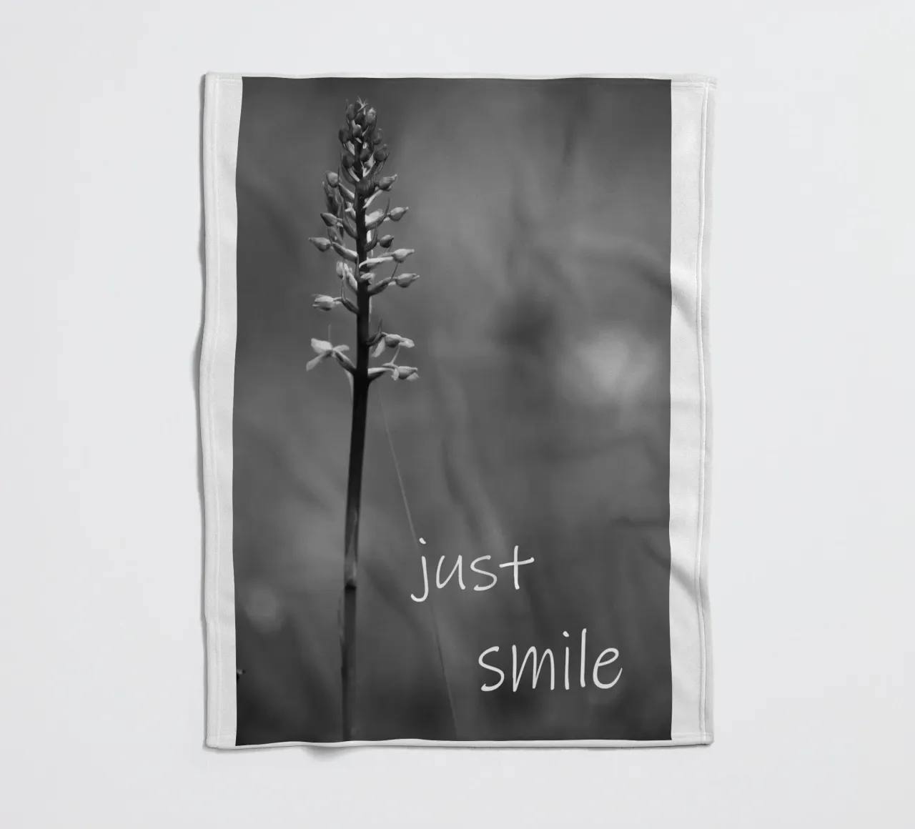 Un fiore di prato in bianco e nero con la scritta coperta in pile da Something for you
