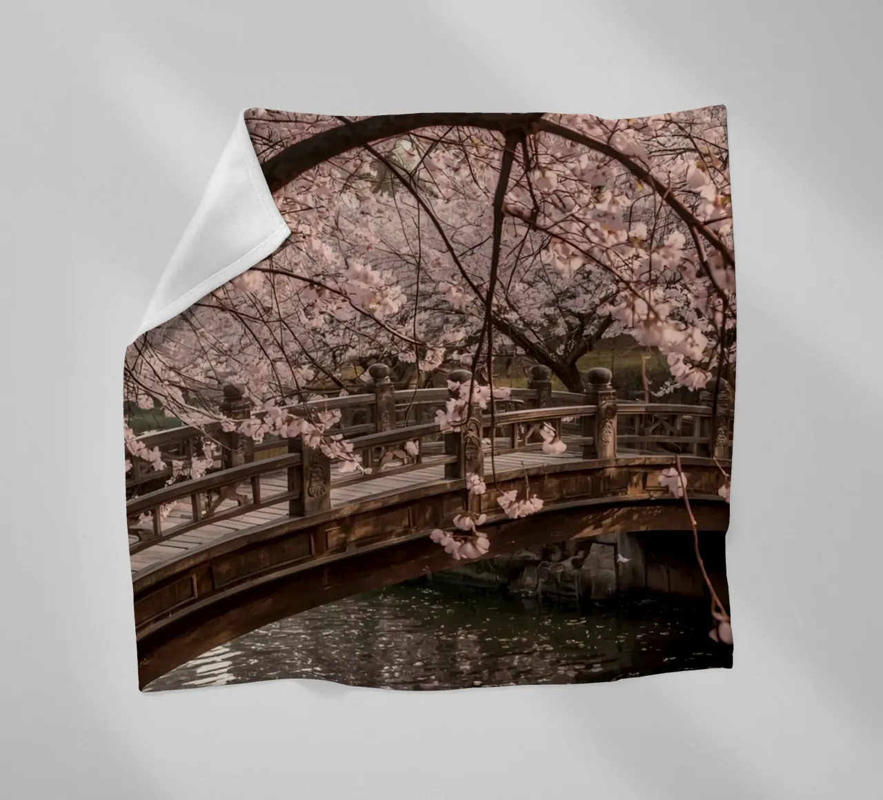 Ponte ad arco in legno con fiori di ciliegio in fiore coperta in pile da DesignDoodle