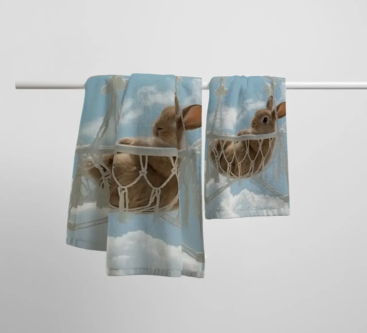 Mignon lapin heureux dans un hamac en macramé sur fond de ciel serviette de bain de DesignDoodle