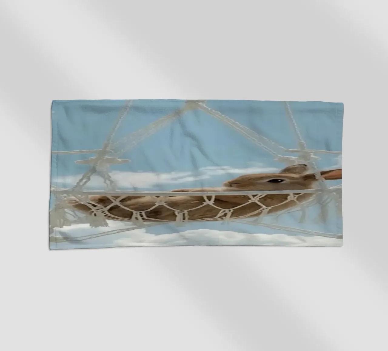Mignon lapin heureux dans un hamac en macramé sur fond de ciel serviette de plage de DesignDoodle