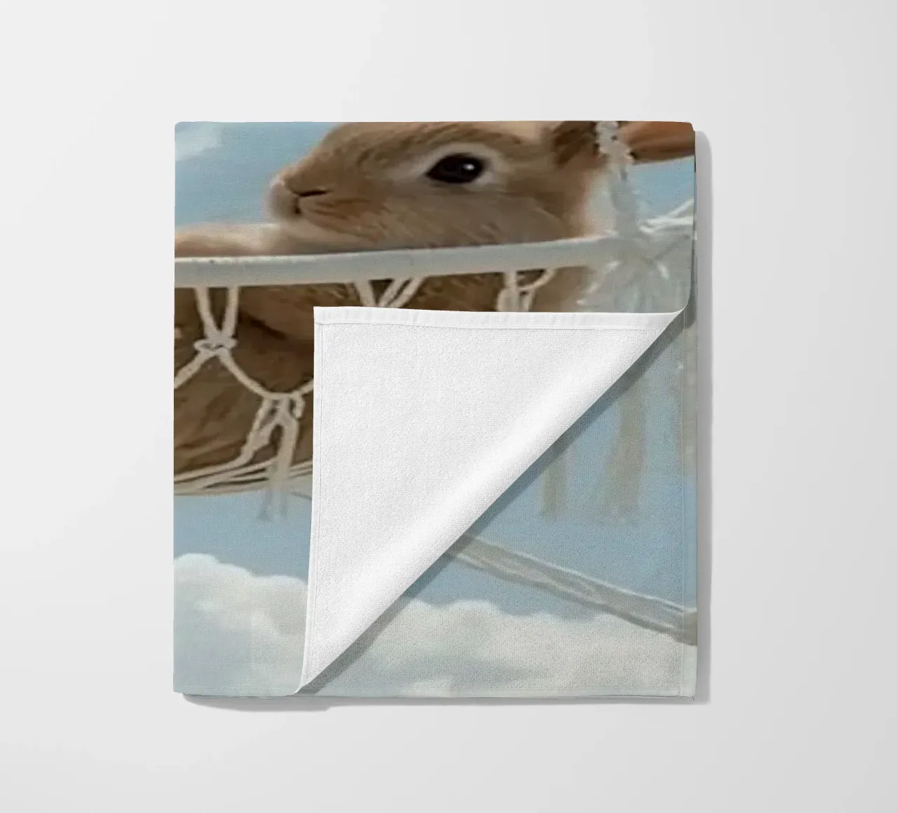 Mignon lapin heureux dans un hamac en macramé sur fond de ciel serviette de plage de DesignDoodle