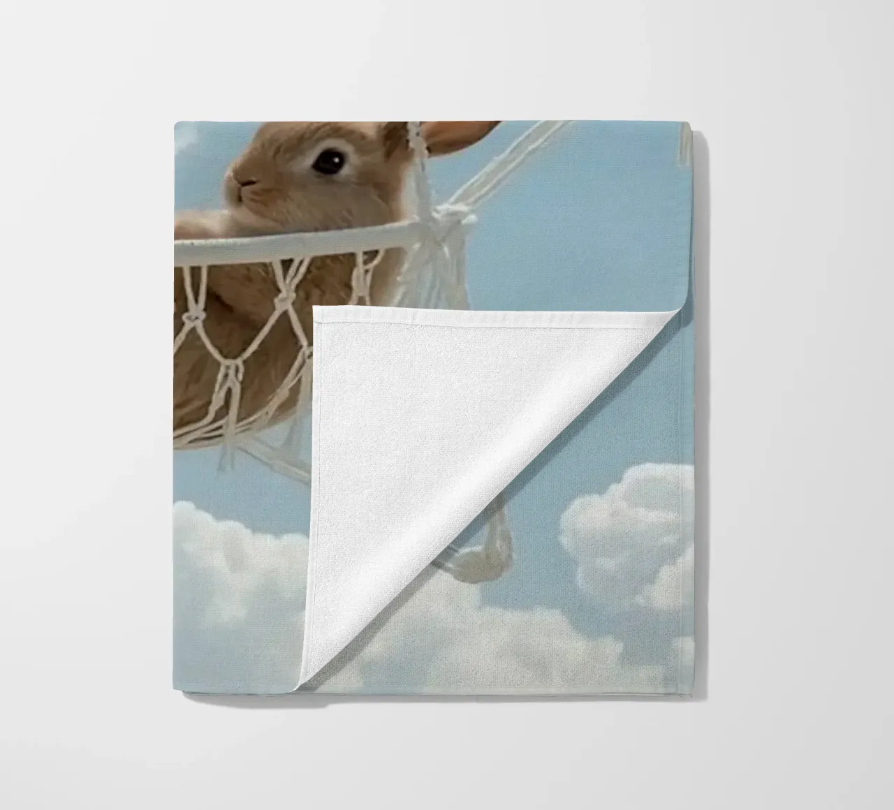 Mignon lapin heureux dans un hamac en macramé sur fond de ciel serviette de plage de DesignDoodle