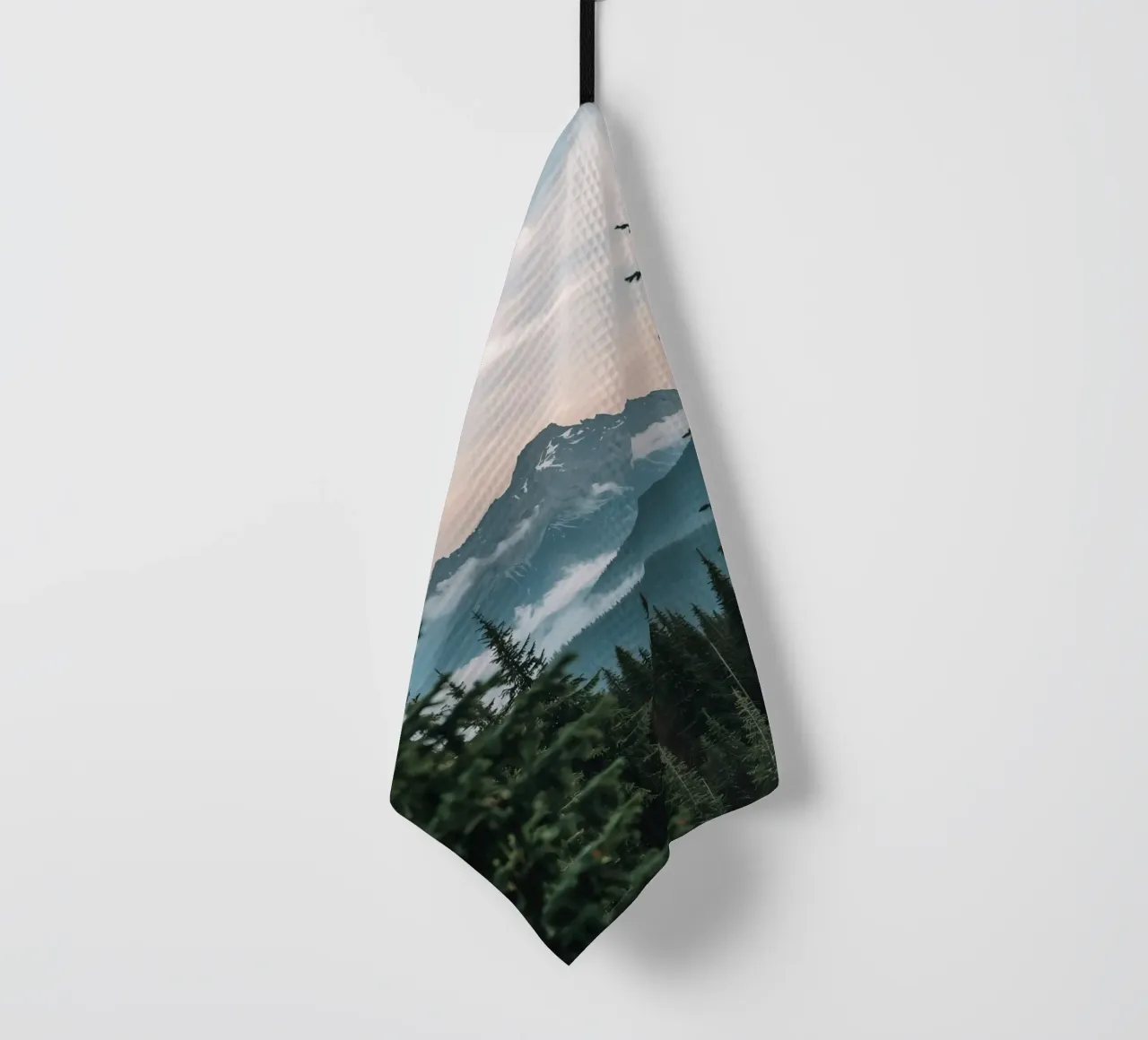 Forêt de conifères encadrant un pic montagneux enneigé torchon de DesignDoodle