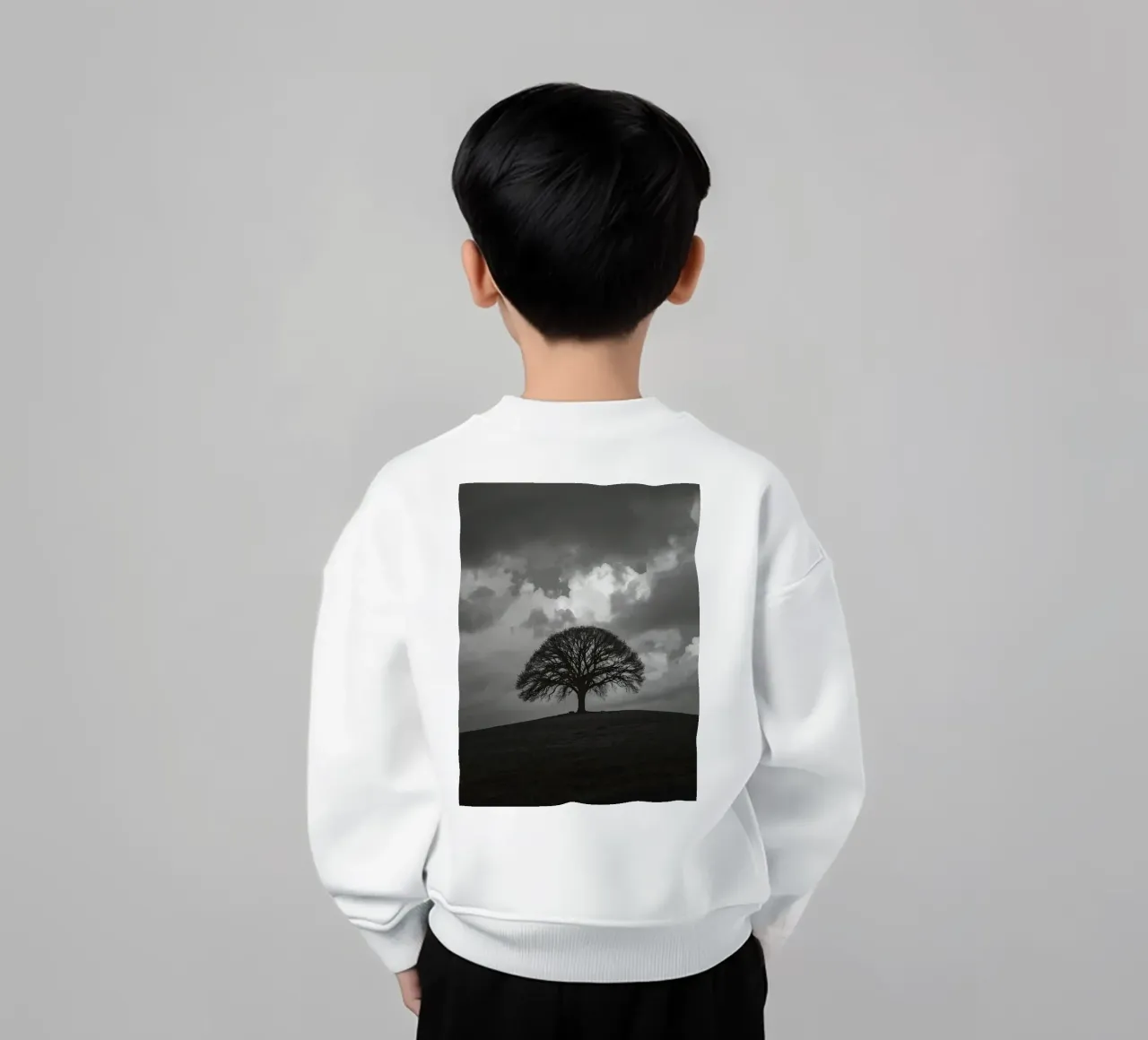 Árbol caducifolio en una colina cubierta de hierba bajo un cielo nublado sudadera para niño de DesignDoodle