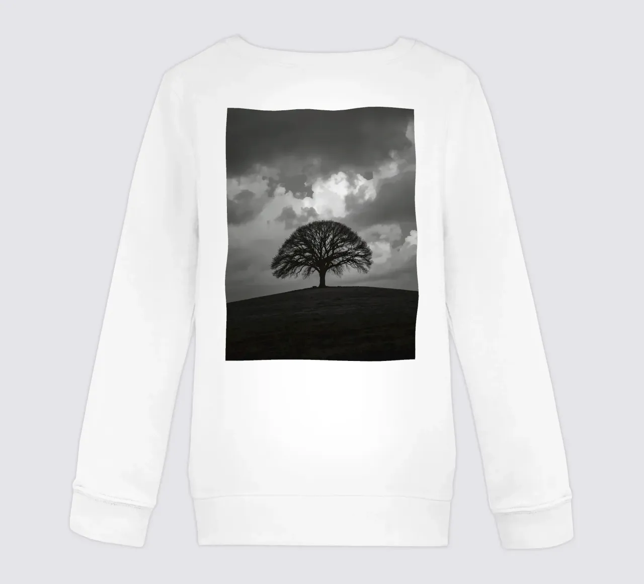 Árbol caducifolio en una colina cubierta de hierba bajo un cielo nublado sudadera para niño de DesignDoodle