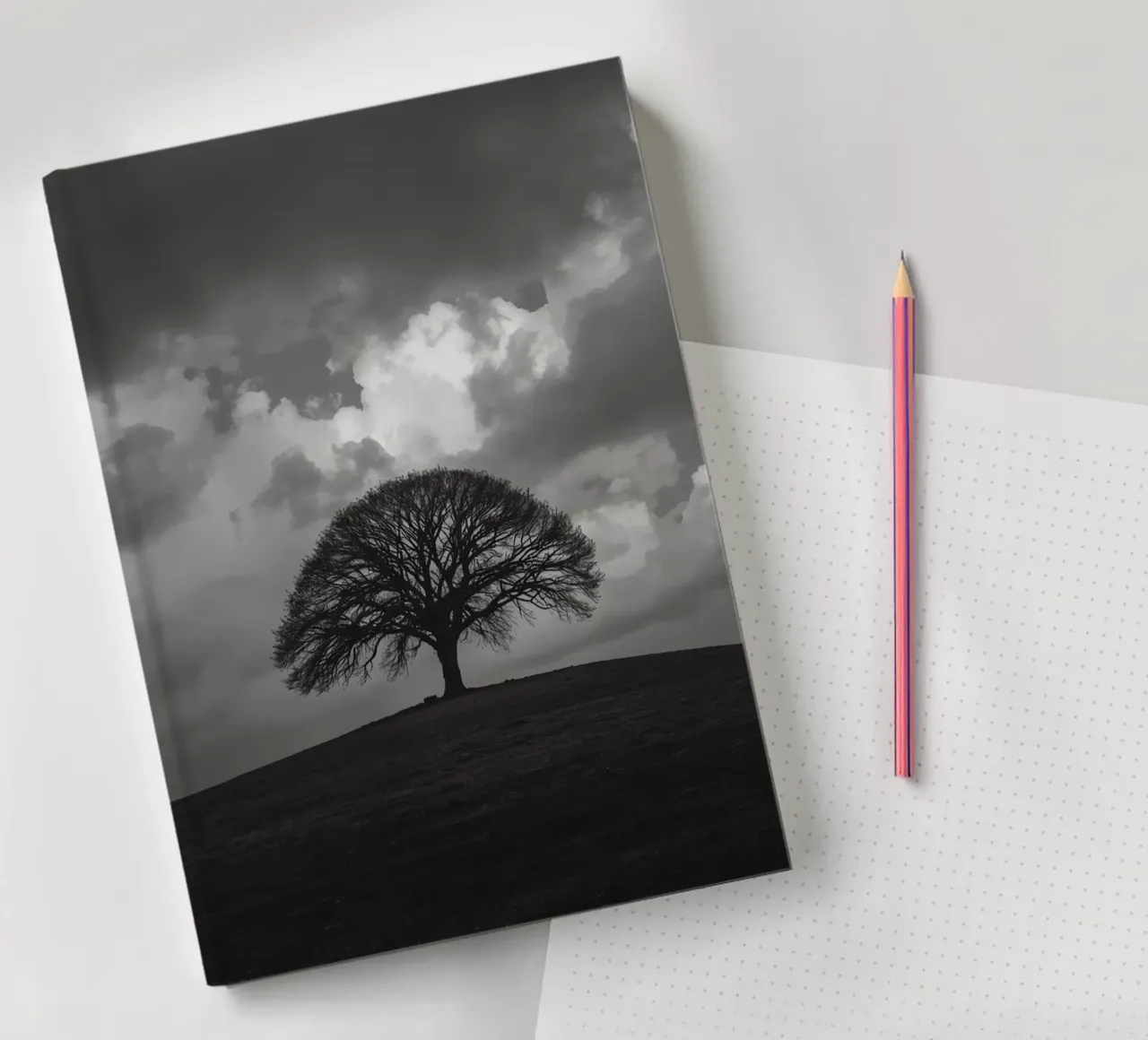 Deciduous Tree on Grassy Hill Under Cloudy Sky notebook by DesignDoodle