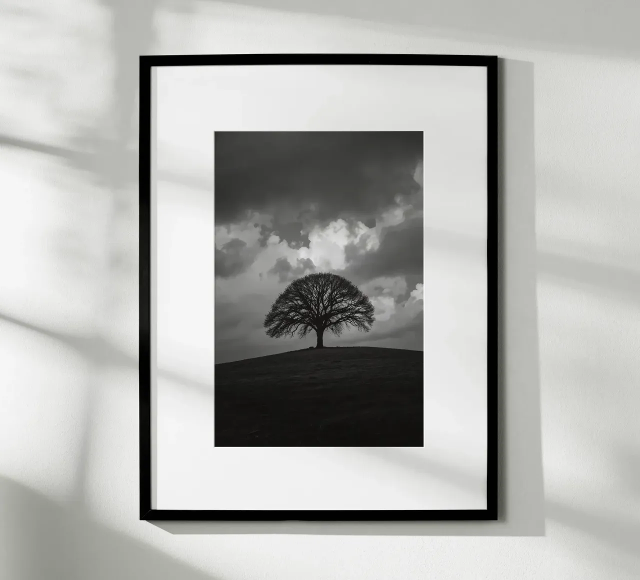 Árbol caducifolio en una colina cubierta de hierba bajo un cielo nublado hahnemühle de DesignDoodle