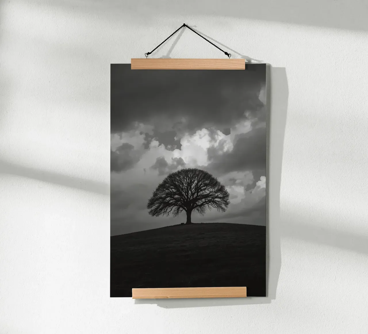 Árbol caducifolio en una colina cubierta de hierba bajo un cielo nublado hahnemühle de DesignDoodle