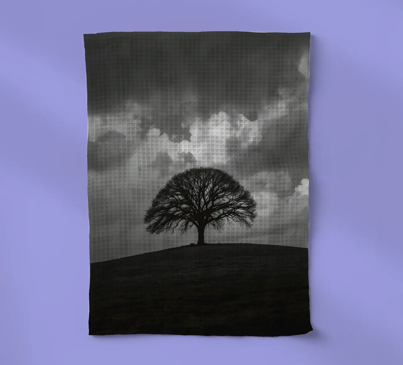 Arbre à feuilles caduques sur une colline herbeuse sous un ciel nuageux torchon de DesignDoodle