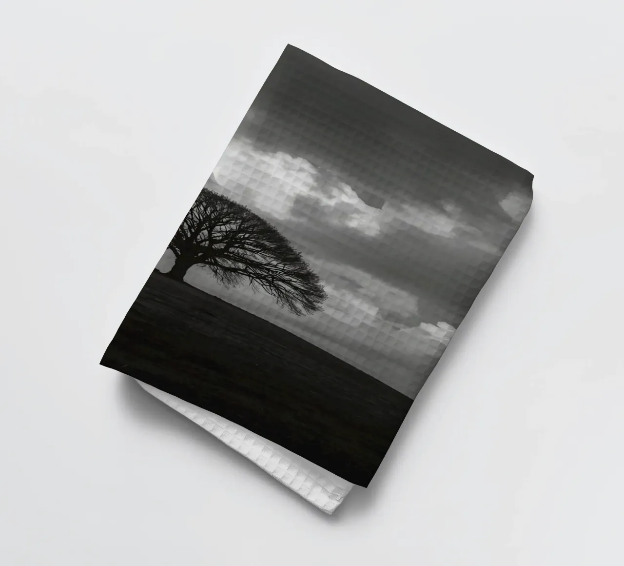 Arbre à feuilles caduques sur une colline herbeuse sous un ciel nuageux torchon de DesignDoodle
