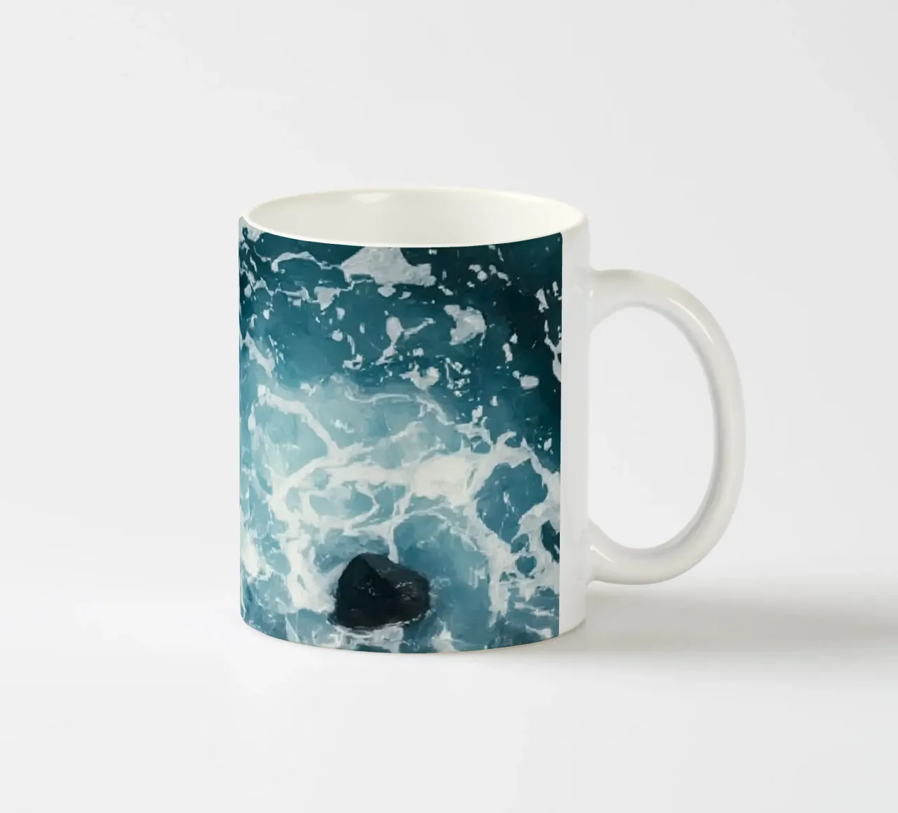 Le onde dell'oceano si infrangono sulle rocce scure tazza in ceramica da DesignDoodle