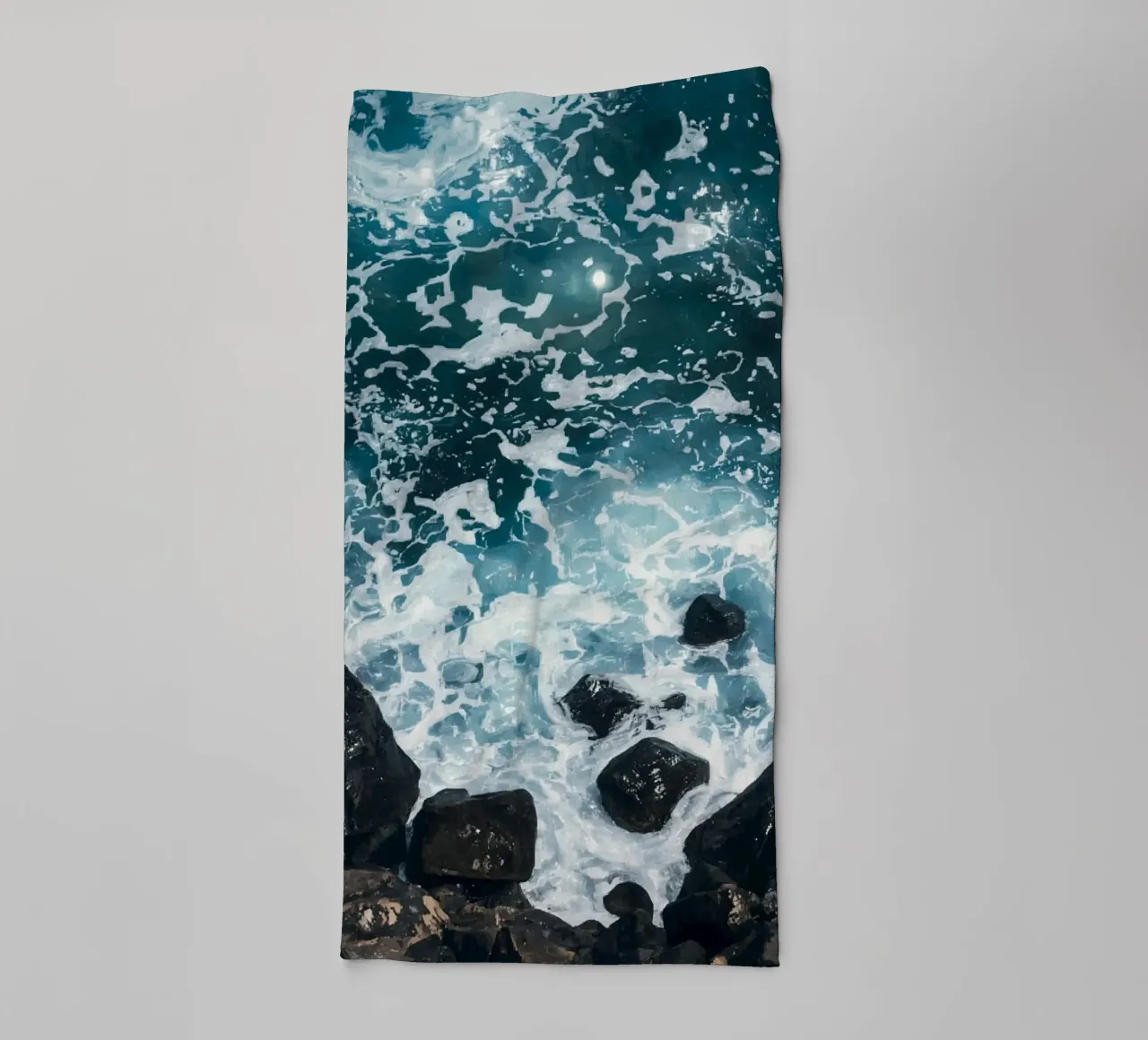 Le onde dell'oceano si infrangono sulle rocce scure asciugamano da bagno da DesignDoodle