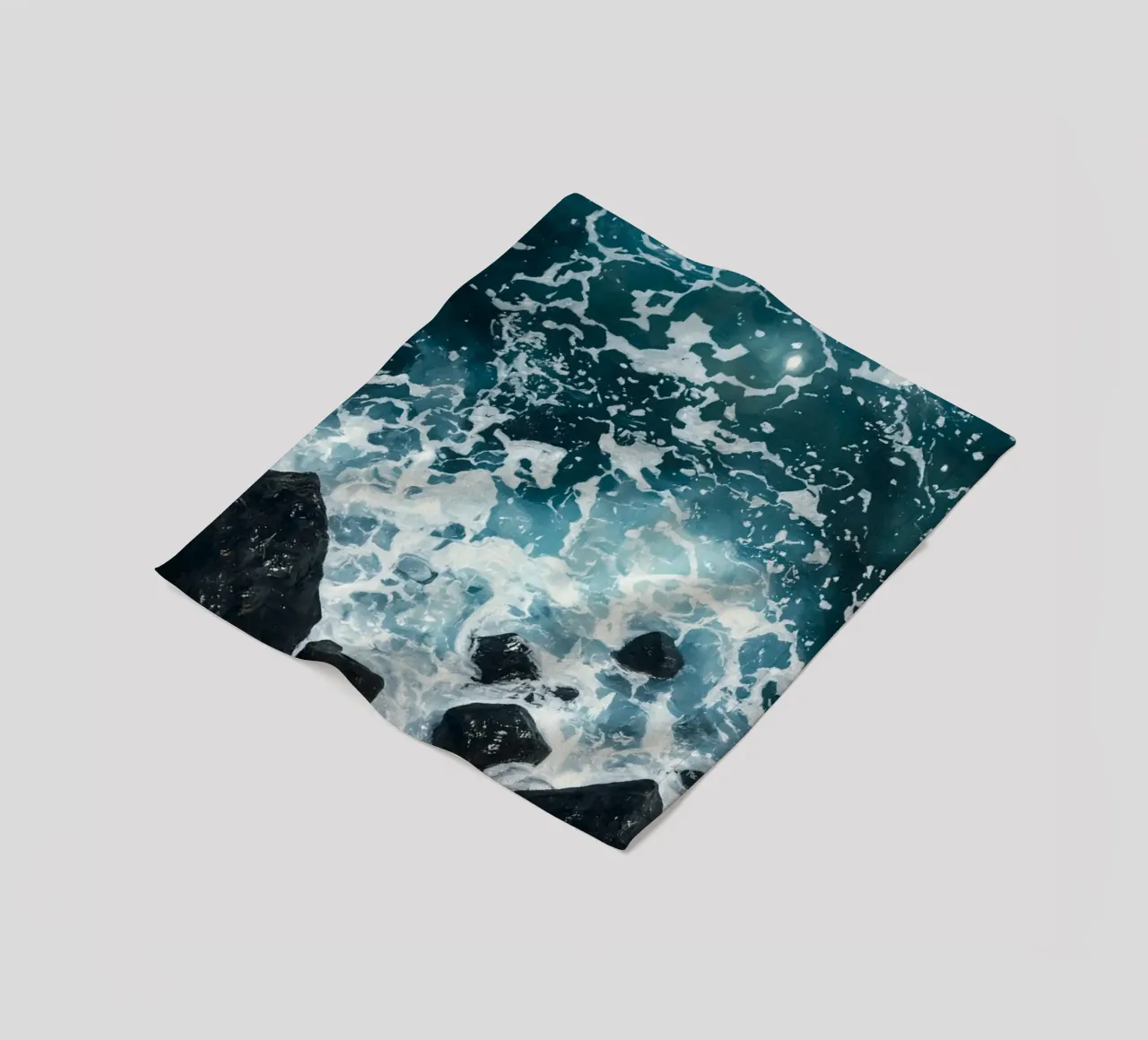 Le onde dell'oceano si infrangono sulle rocce scure coperta in pile da DesignDoodle