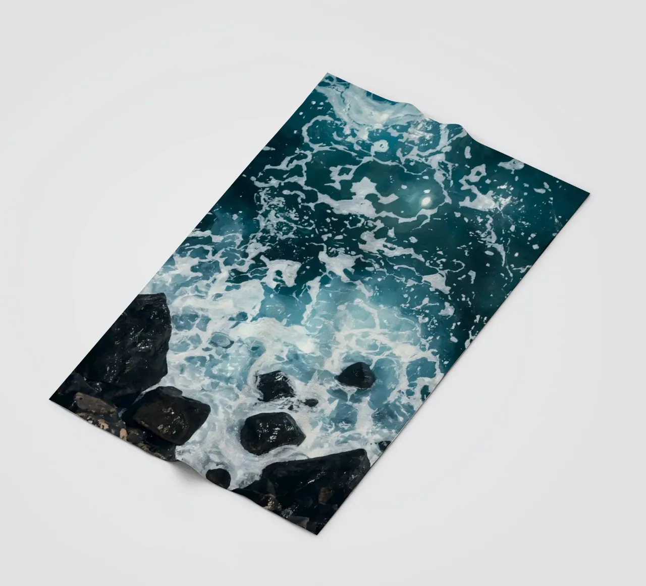 Le onde dell'oceano si infrangono sulle rocce scure coperta in pile da DesignDoodle