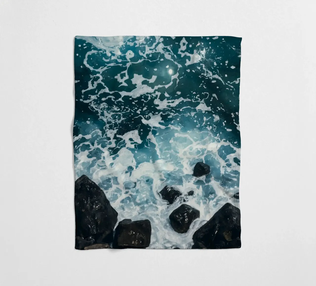 Le onde dell'oceano si infrangono sulle rocce scure coperta in pile da DesignDoodle