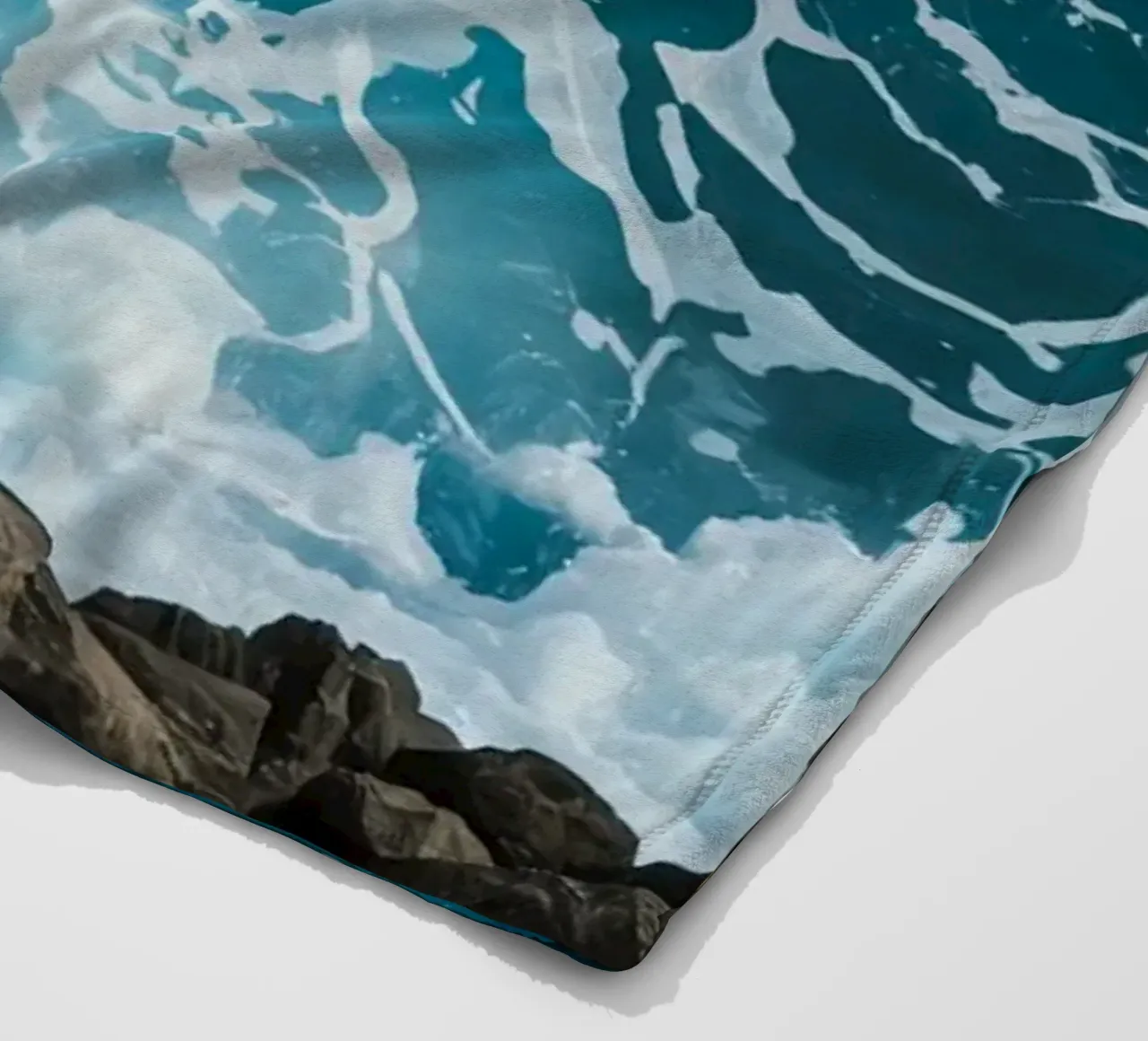 Onde oceaniche che si infrangono sulle rocce coperta in pile da DesignDoodle