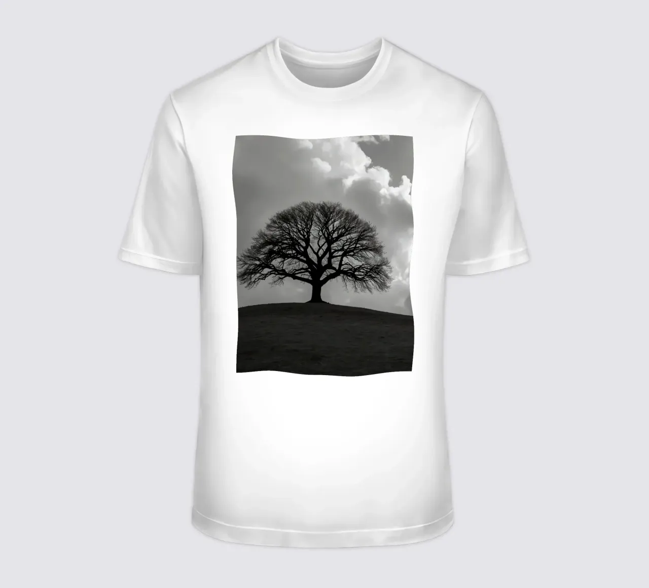 Sagoma di un albero spoglio su una collina contro un cielo nuvoloso t-shirt da DesignDoodle