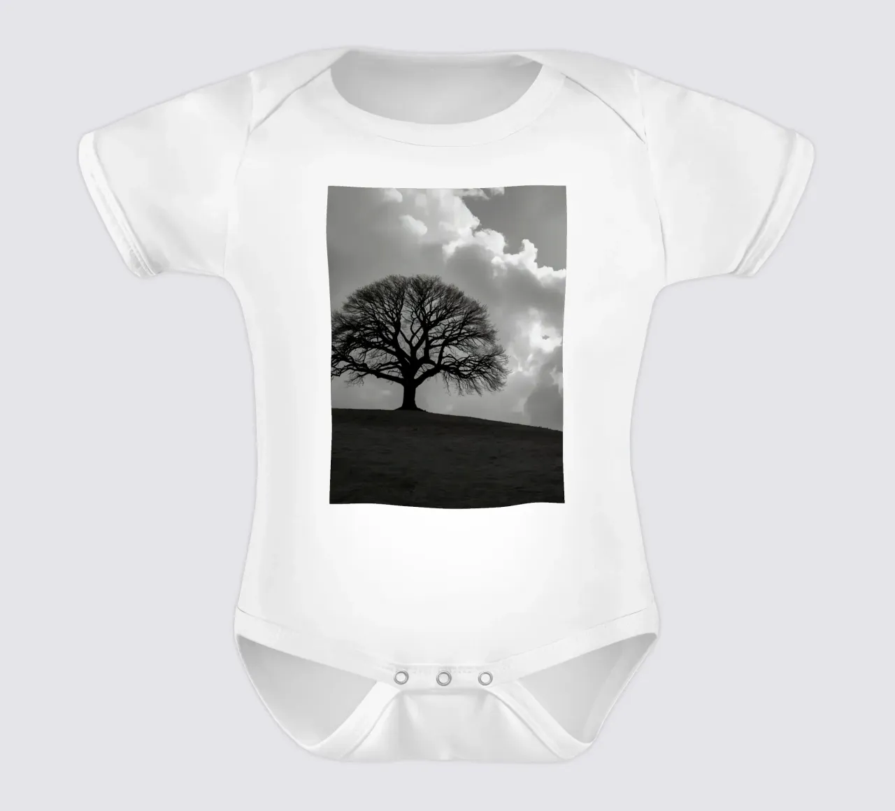 Sagoma di un albero spoglio su una collina contro un cielo nuvoloso body neonato maniche corte da DesignDoodle