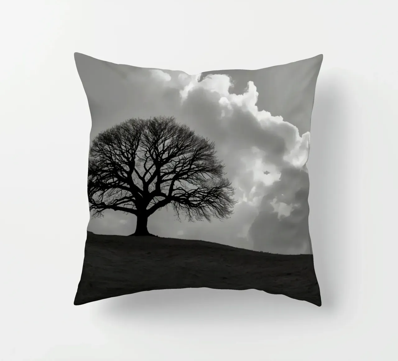 Sagoma di un albero spoglio su una collina contro un cielo nuvoloso cuscino da DesignDoodle