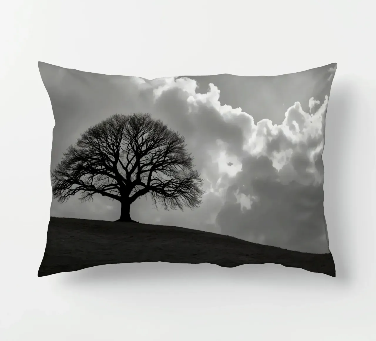 Sagoma di un albero spoglio su una collina contro un cielo nuvoloso cuscino da DesignDoodle