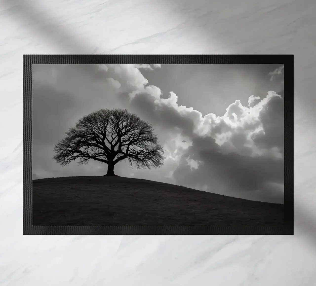 Silhouette of a bare tree on a hill against a cloudy sky doormat by DesignDoodle