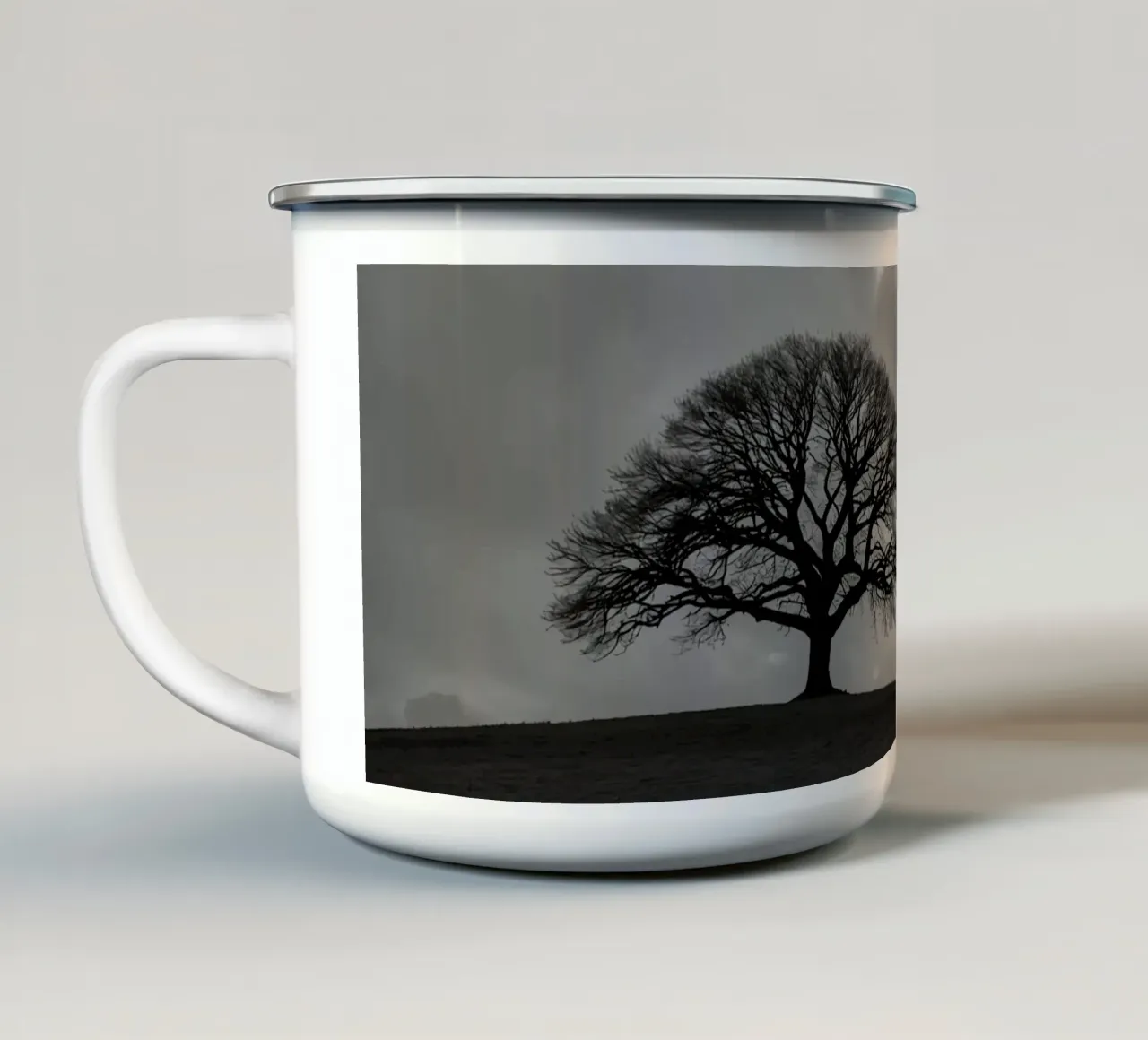 Sagoma di un albero spoglio su una collina contro un cielo nuvoloso tazza in smalto da DesignDoodle