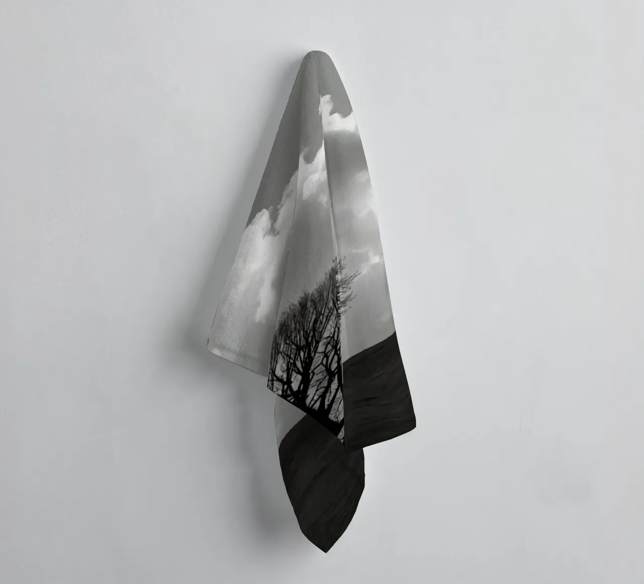 Silhouette of a bare tree on a hill against a cloudy sky towel by DesignDoodle