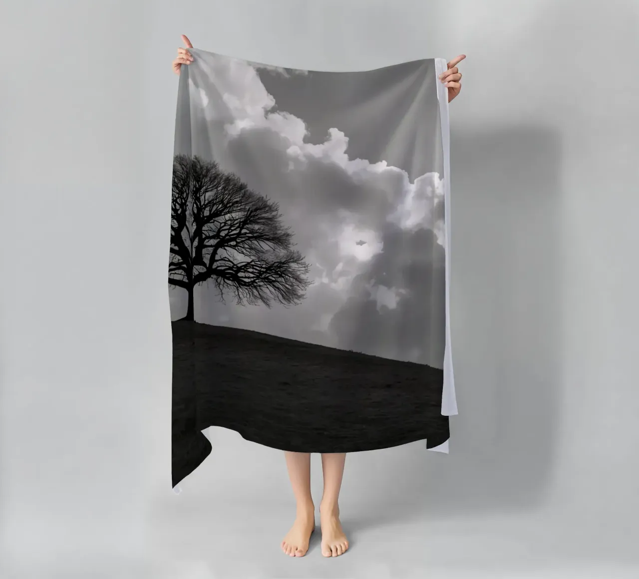 Sagoma di un albero spoglio su una collina contro un cielo nuvoloso telo mare da DesignDoodle