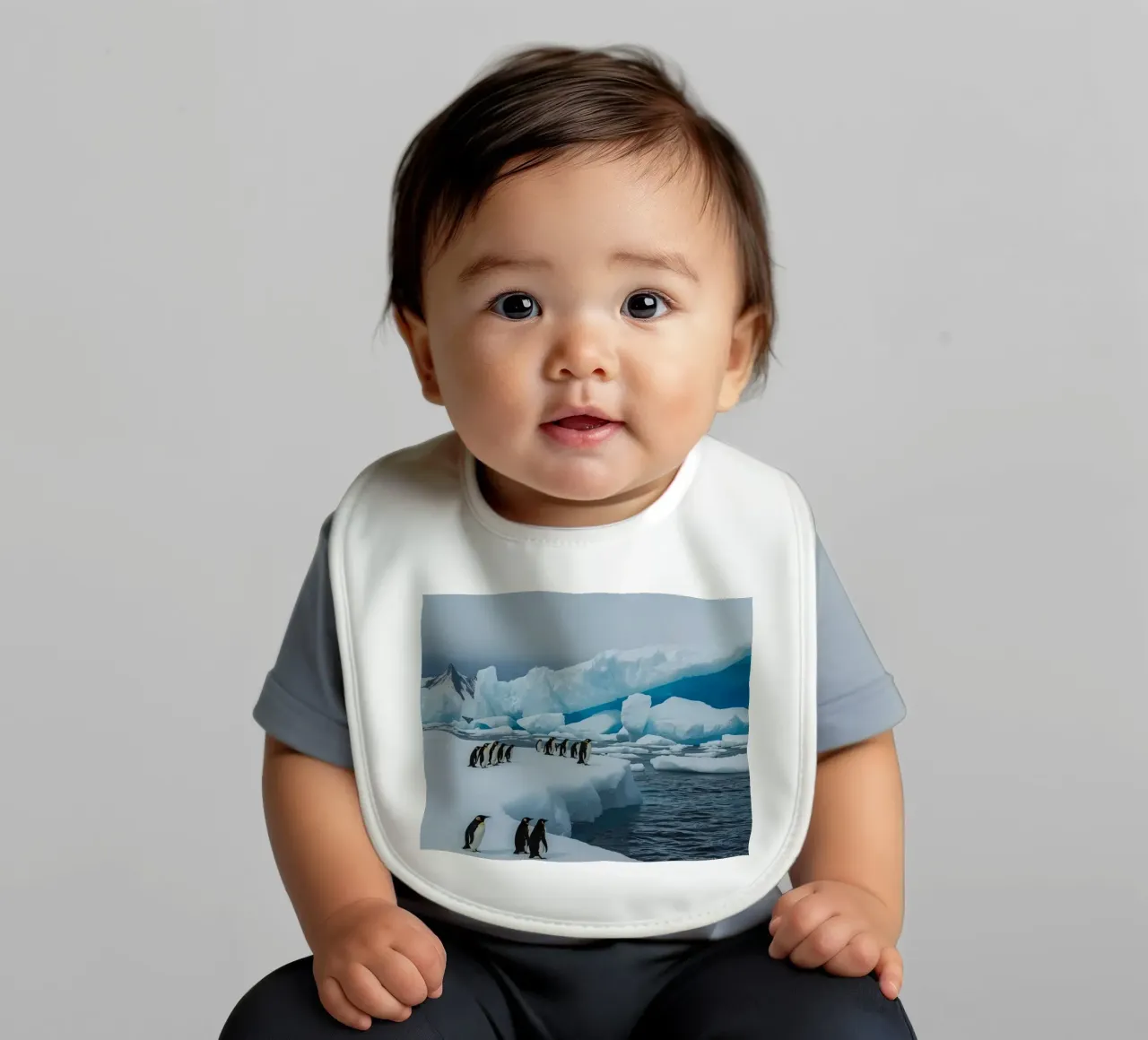 Pinguini imperatore su una distesa di ghiaccio con iceberg e montagne bavaglino da DesignDoodle