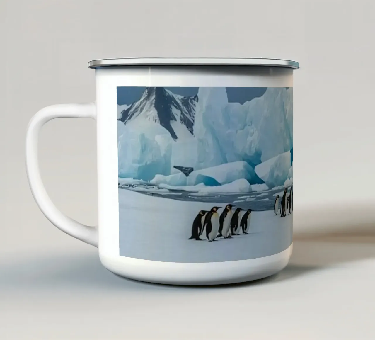 Pinguini imperatore su una distesa di ghiaccio con iceberg e montagne tazza in smalto da DesignDoodle