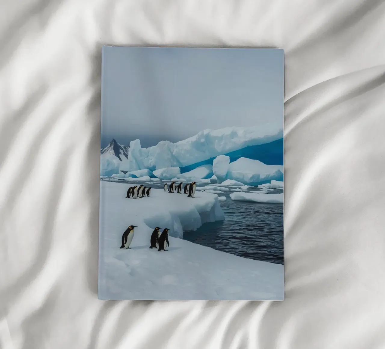 Emperor Penguins on Ice Floe with Icebergs and Mountains notebook by DesignDoodle