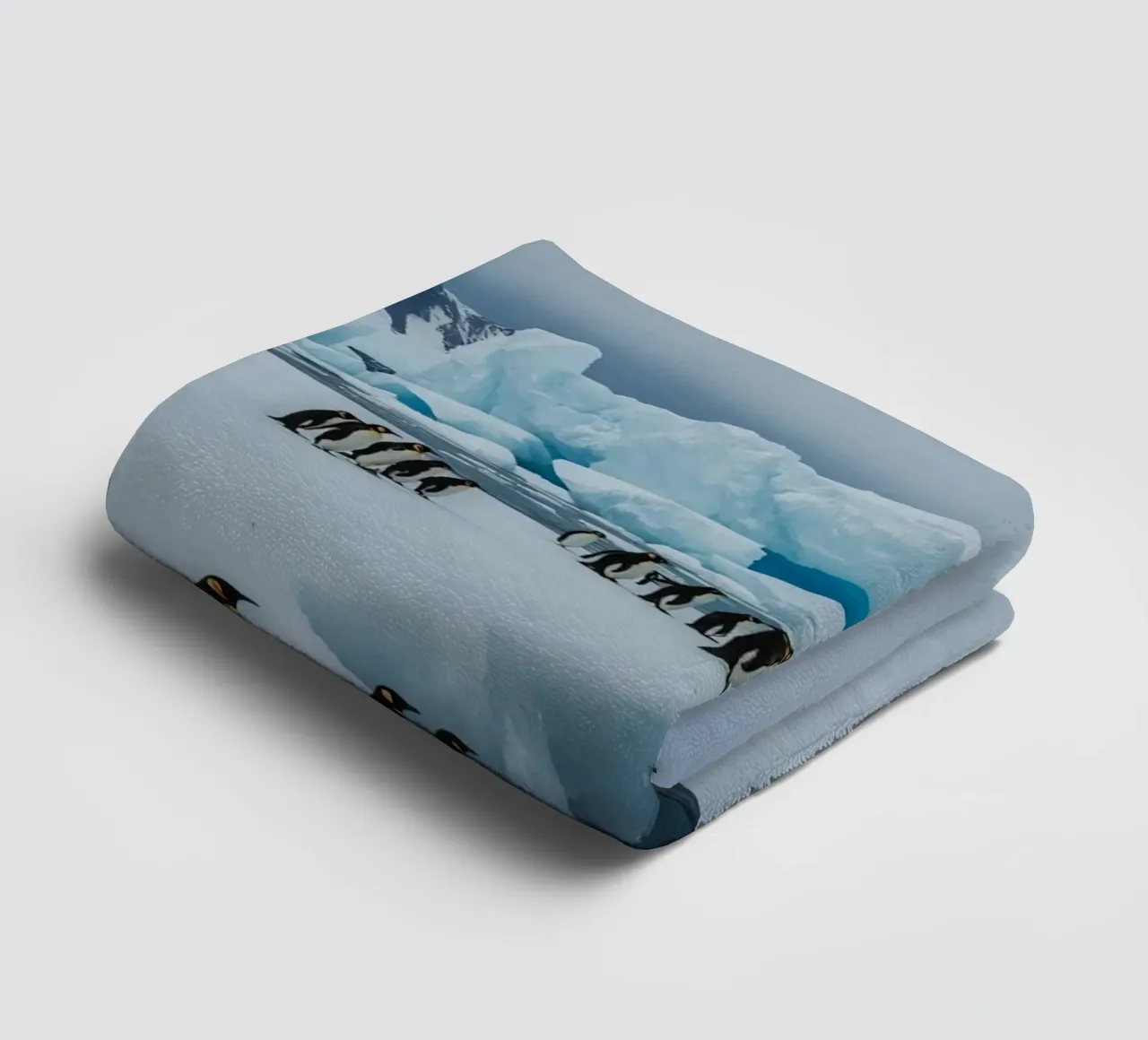 Pinguini imperatore su una distesa di ghiaccio con iceberg e montagne asciugamano da bagno da DesignDoodle