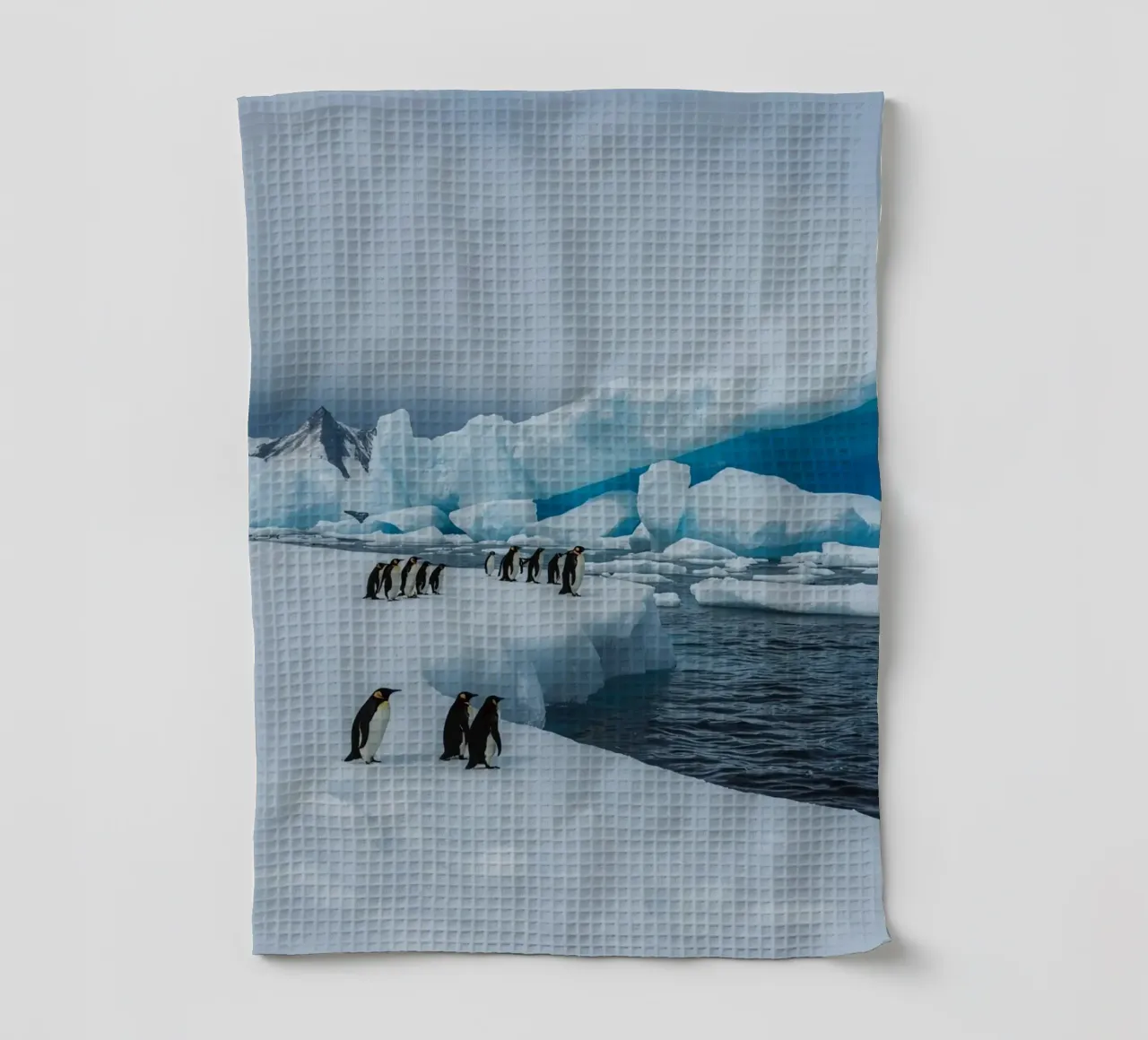 Pinguini imperatore su una distesa di ghiaccio con iceberg e montagne canovaccio da cucina da DesignDoodle