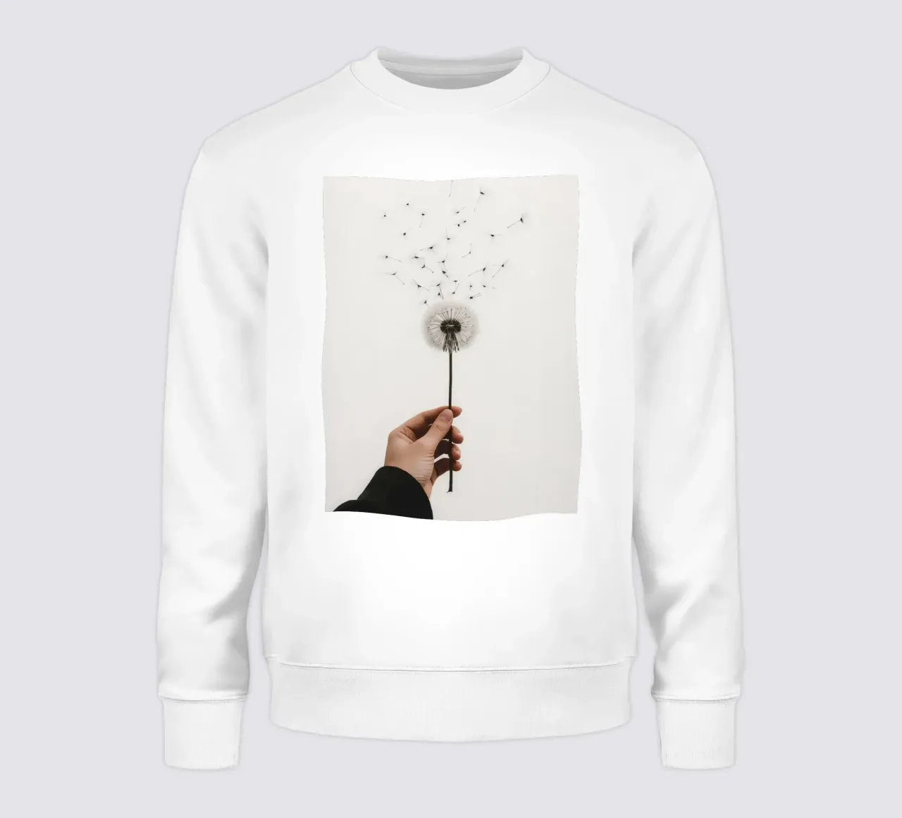 Mano che tiene il dente di leone con semi volanti felpa da DesignDoodle