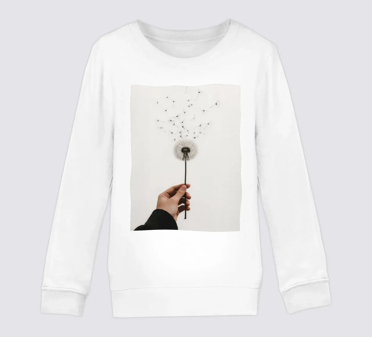 Mano que sostiene un diente de león con semillas voladoras sudadera para niño de DesignDoodle