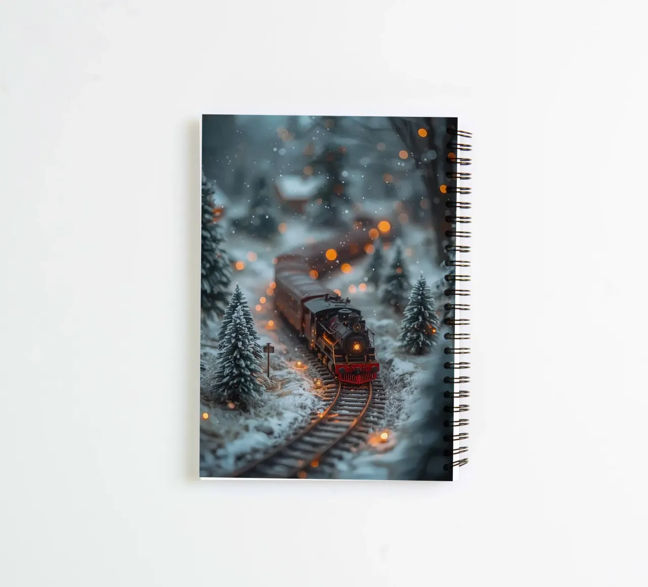 Train à vapeur miniature dans une forêt d'hiver avec des lumières bokeh carnet à spirale de DesignDoodle