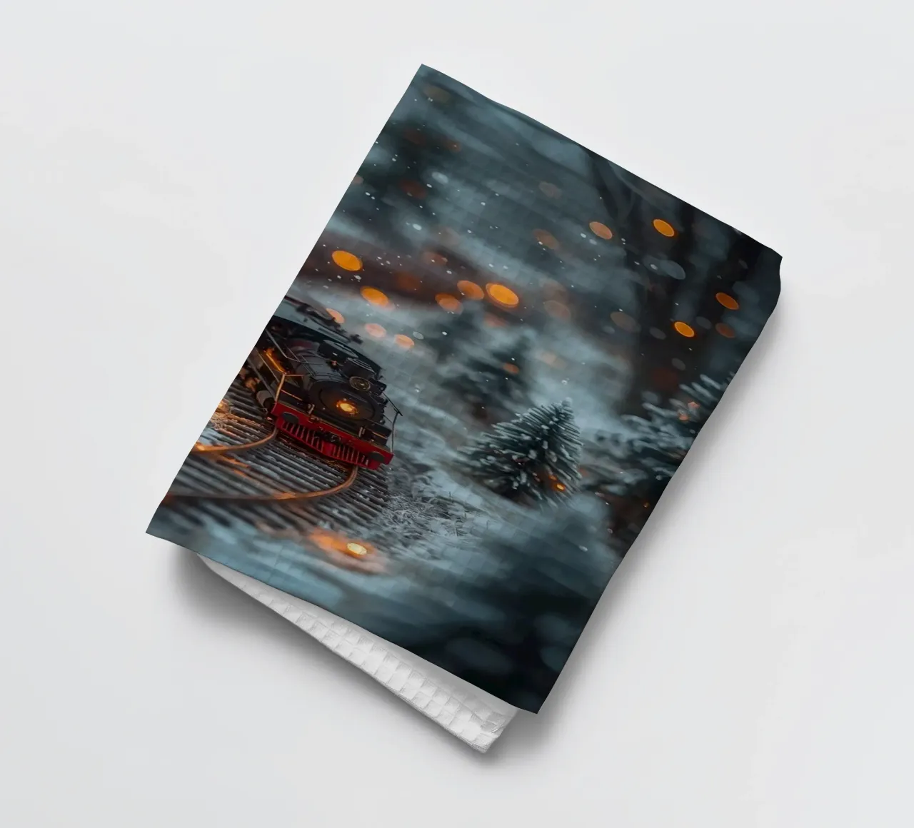 Train à vapeur miniature dans une forêt d'hiver avec des lumières bokeh torchon de DesignDoodle