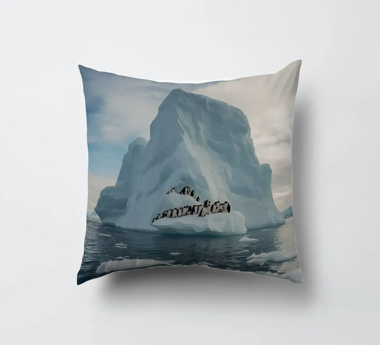 Pinguini su un iceberg in acque fredde cuscino da DesignDoodle