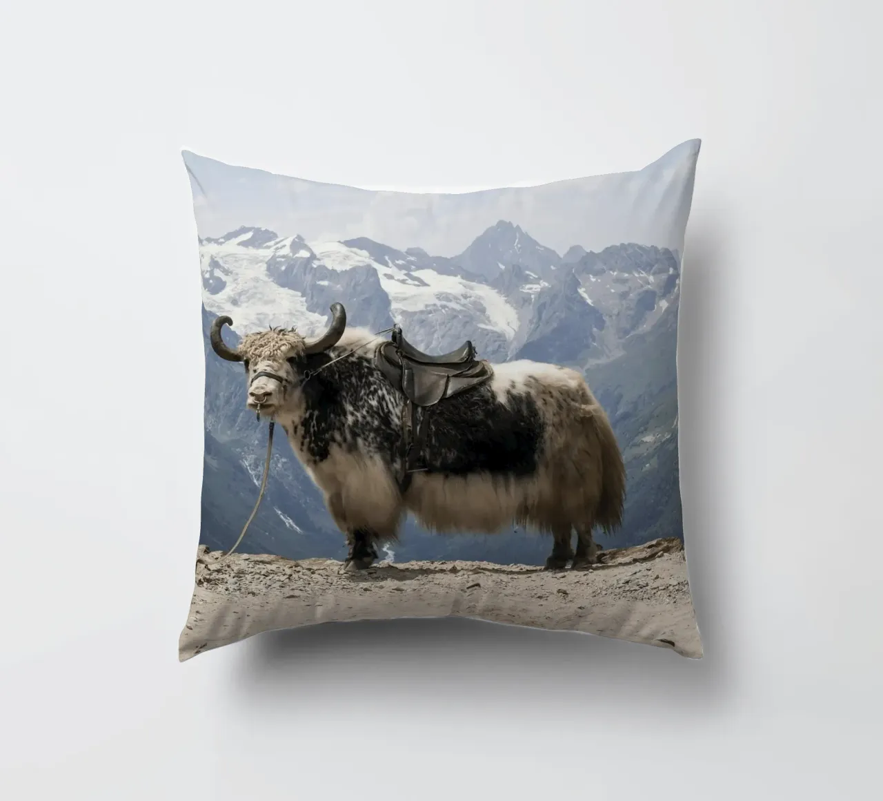 Yak in piedi su uno sfondo montano innevato cuscino da The Herringstore