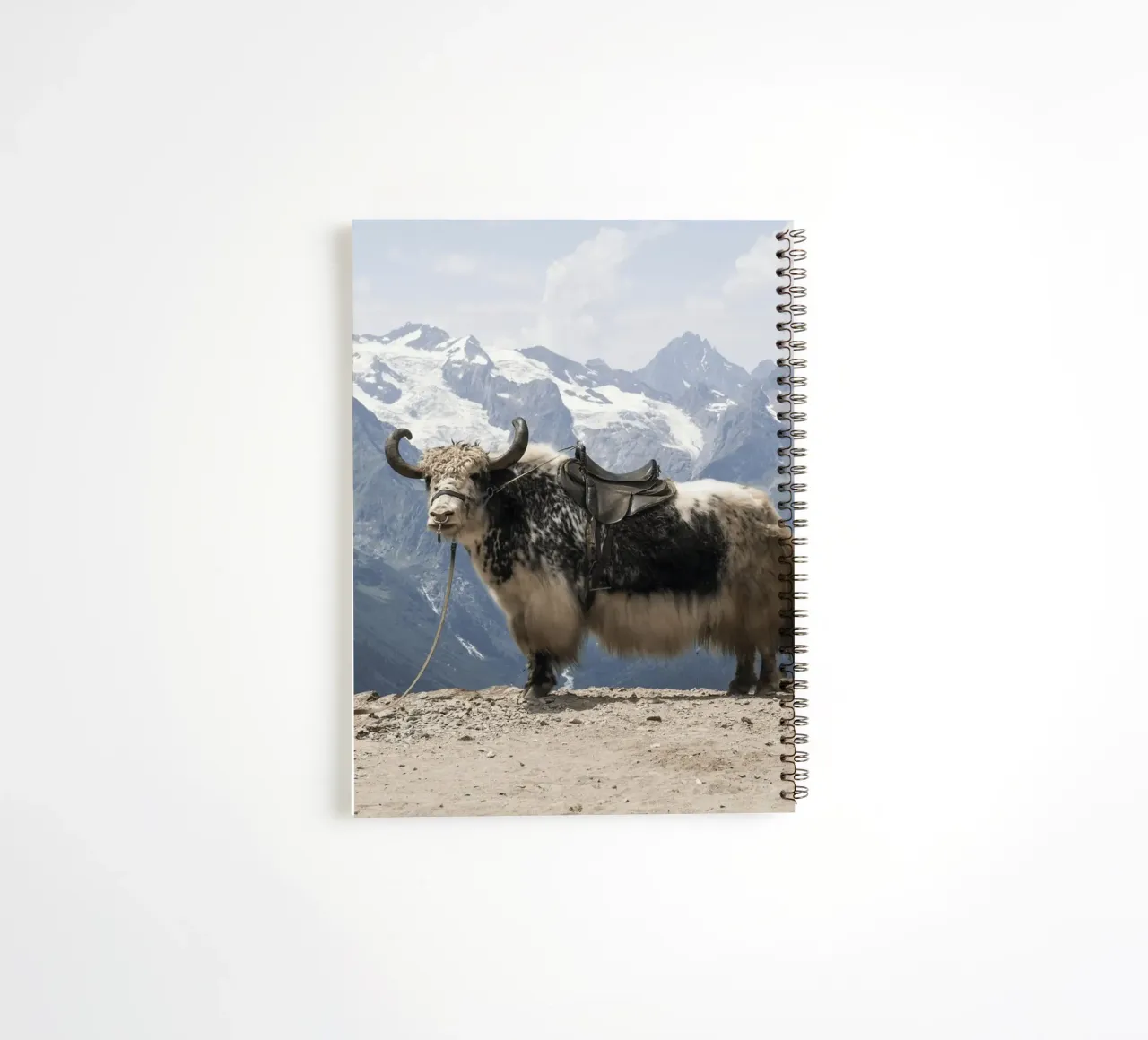 Yak Standing on a Snowy Mountain Backdrop spiral notebook by The Herringstore