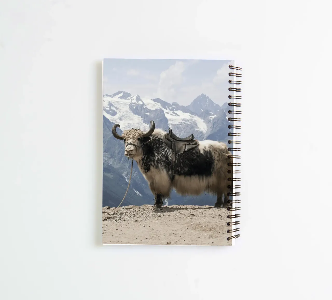 Yak Standing on a Snowy Mountain Backdrop spiral notebook by The Herringstore