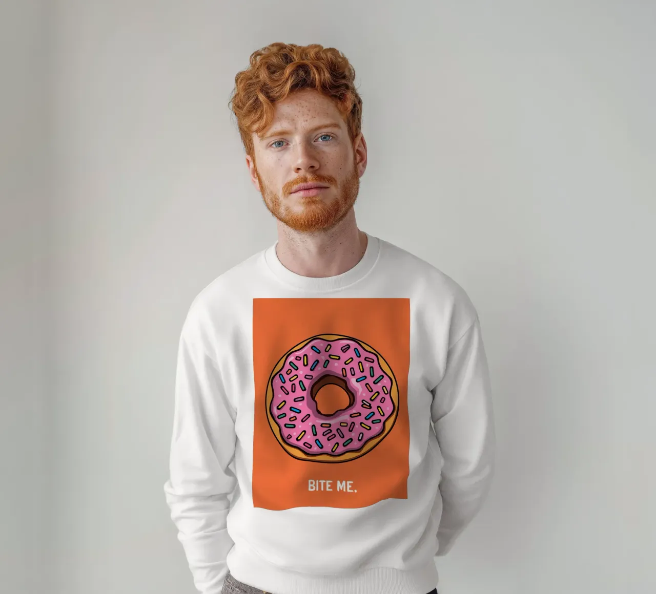 Rosa Frosted Donut "Bite Me" auf orangem Hintergrund Sweatshirt von DesignDoodle