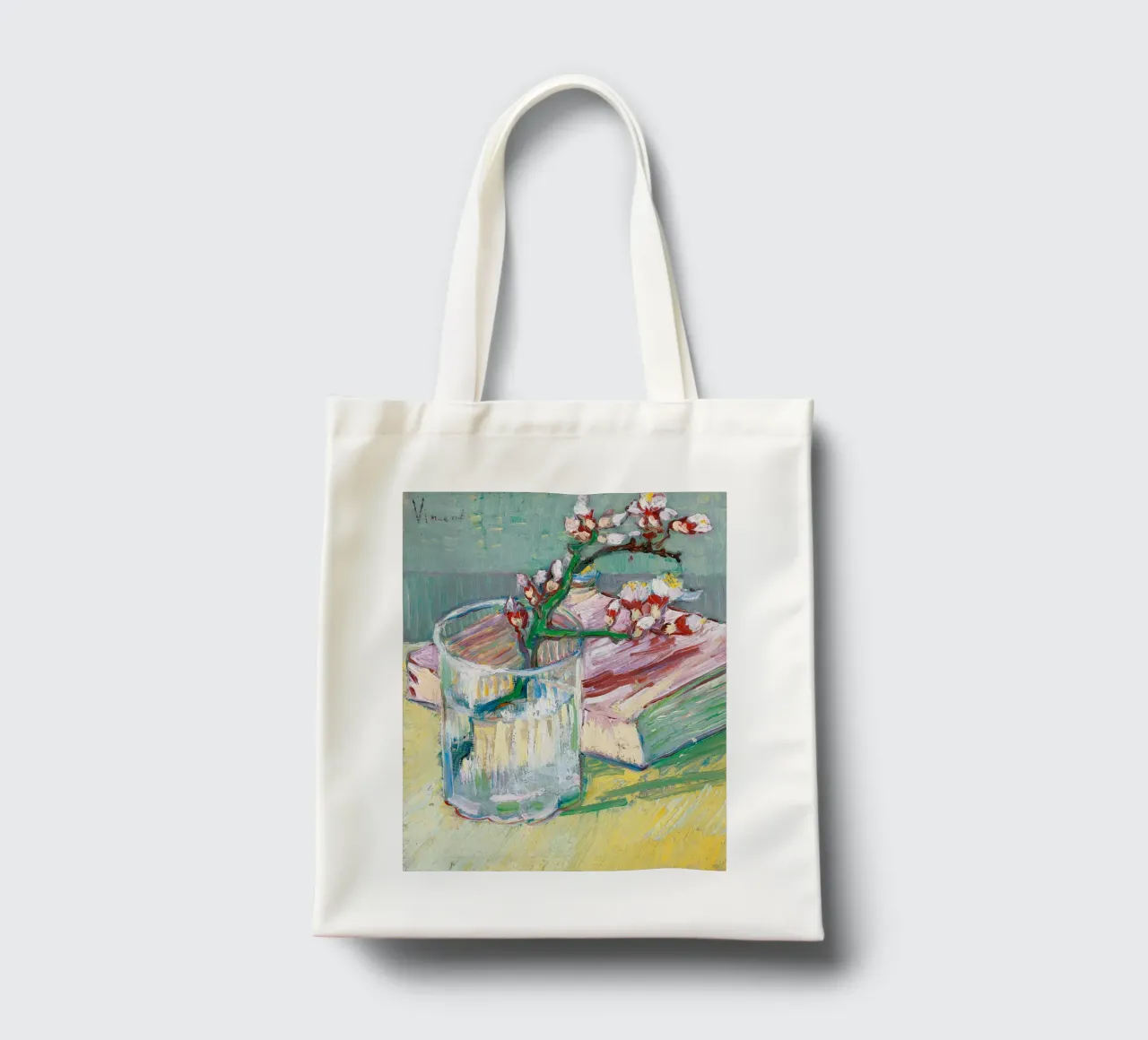 Ramo di mandorlo fiorito in un bicchiere con un libro borsa in juta da Roy Terrell