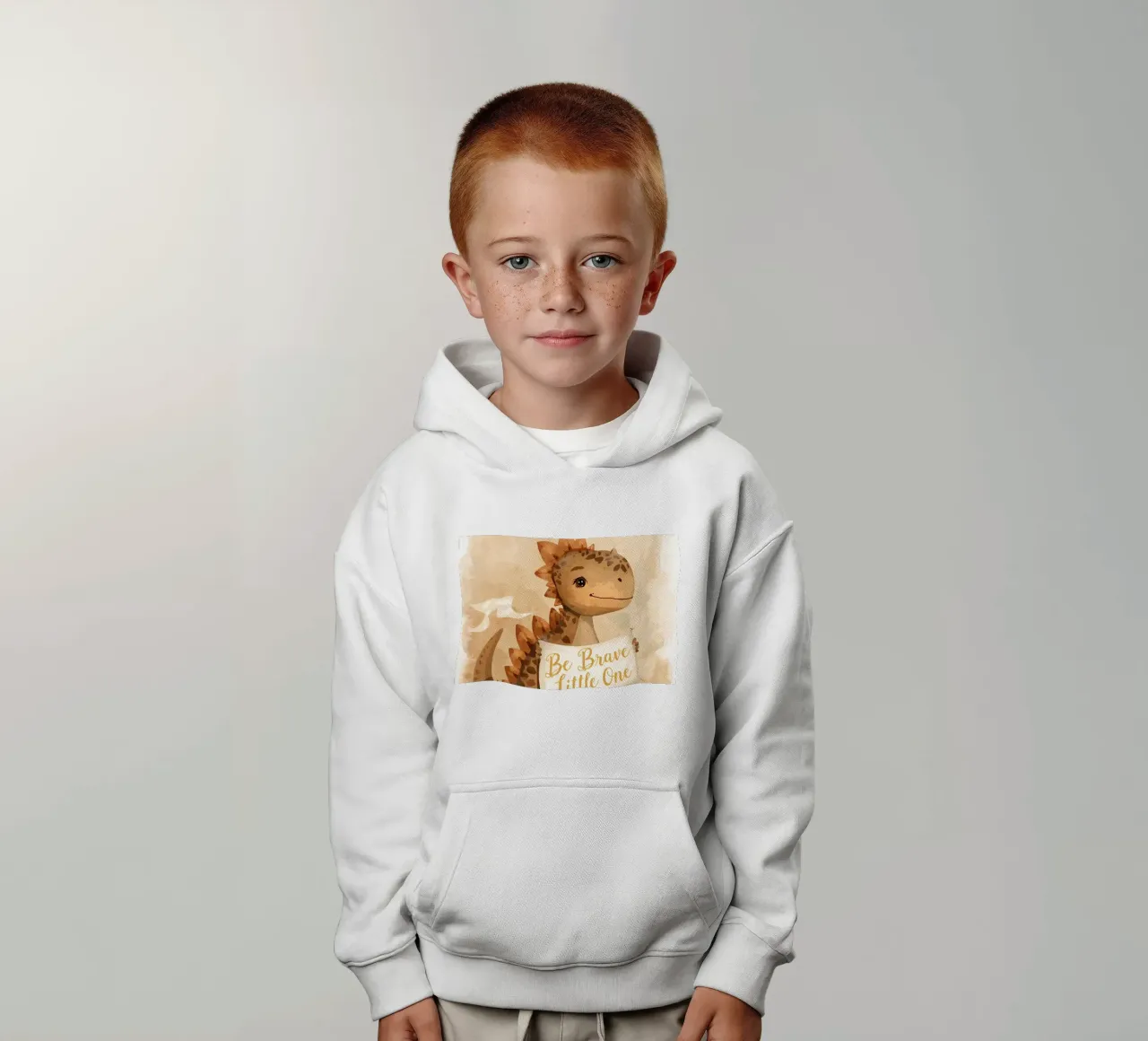 Un simpatico dinosauro con in mano lo striscione "Be Brave Little One". felpa bambino con cappuccio da DesignDoodle